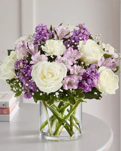 Lovely memories are made with thoughtful gifts for the ones we care about. Our charming bouquet is loosely gathered with a medley of lavender & white blooms. Hand-designed inside a clear cylinder vase with cascading greenery all around, it’s a wonderful way to express the sentiments you have inside your heart.