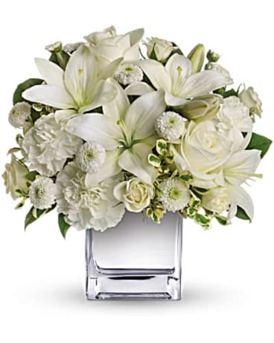 This exquisite all-white bouquet in a dazzling mirrored silver cube may be petite, but it will make a huge impression.
So much beauty for such a merrily modest price tag.
The lovely bouquet includes white roses, white spray roses, white Asiatic lilies, white carnations and white button spray chrysanthemums accented with assorted greenery.