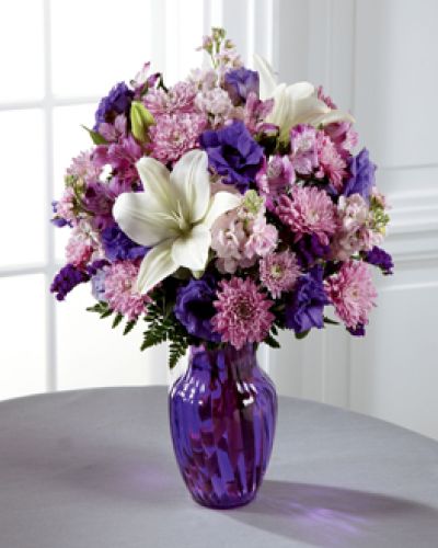 <p>Everyone loves a little purple in their life - it's elegance, it's twilight magic, it's expression of the unexpected. Send your recipient every shade of purple nature can supply with this flower arrangement, bringing together lavender gilly flower, purple double lisianthus, lavender chrysanthemums, purple Peruvian Lilies, and purple statice, accented with white Asiatic Lilies and lush greens presented in a modern purple glass vase.</p>